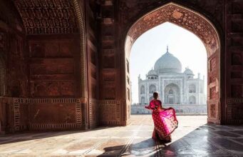 5 Must-Visit Monuments to See: Explore India’s Iconic Landmarks lady in pink dress dancing in front of taj mahal